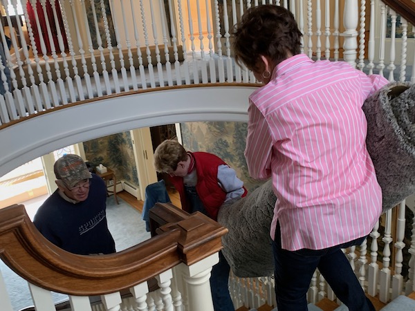 Women carrying a rug downstairs to help the Historic Stanley Home