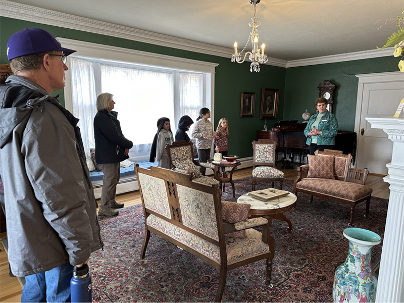 a group of tourists taking a guided tour at the stanley home museum