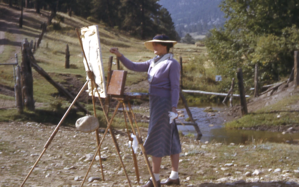 dorothy stanley emmons painting on a canvas with the rocky mountains in the background